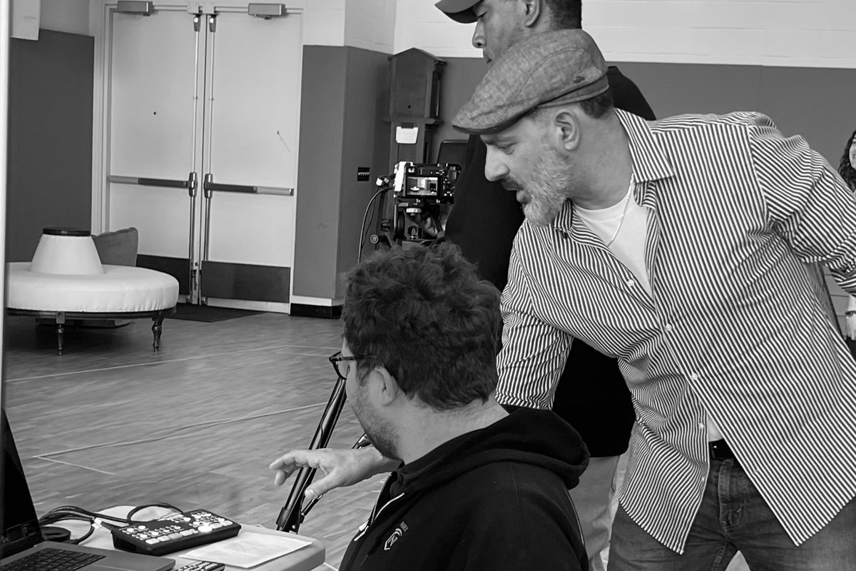 Patrick Sabongui leading a live production workshop, shown in black and white with the production switcher in color